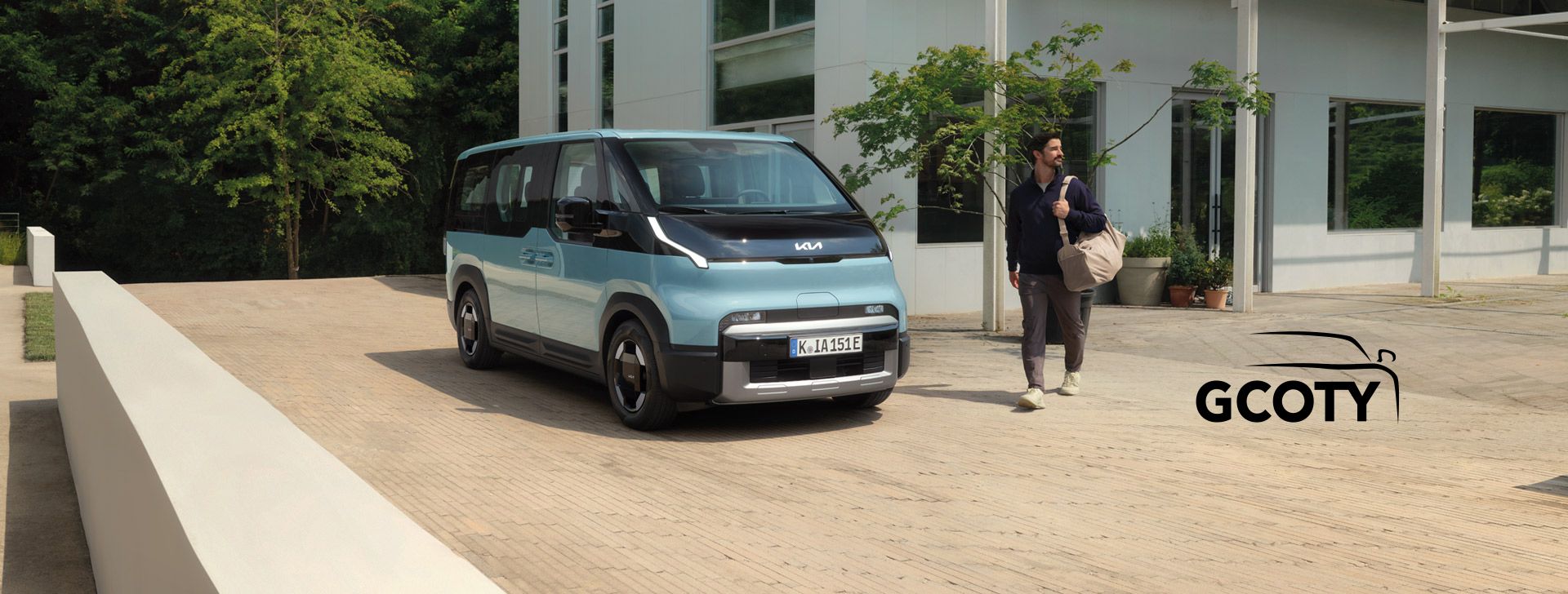 Kia PV5 Passenger vor einem modernen Gebäude in Vorderansicht mit Talent
